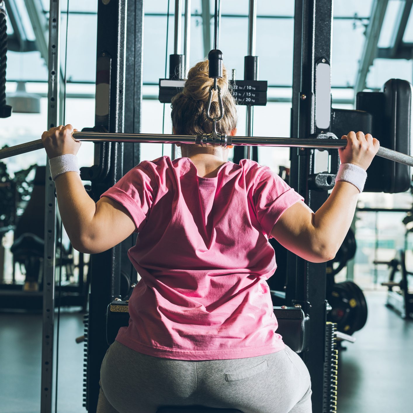 overweight woman working out on training apparatus